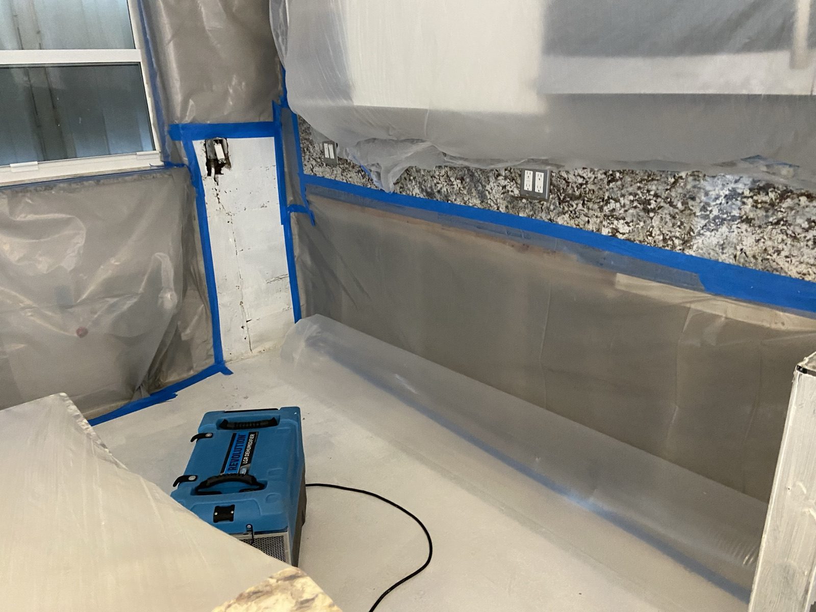 Containment with poly sheeting and a dehumidifier during structural drying